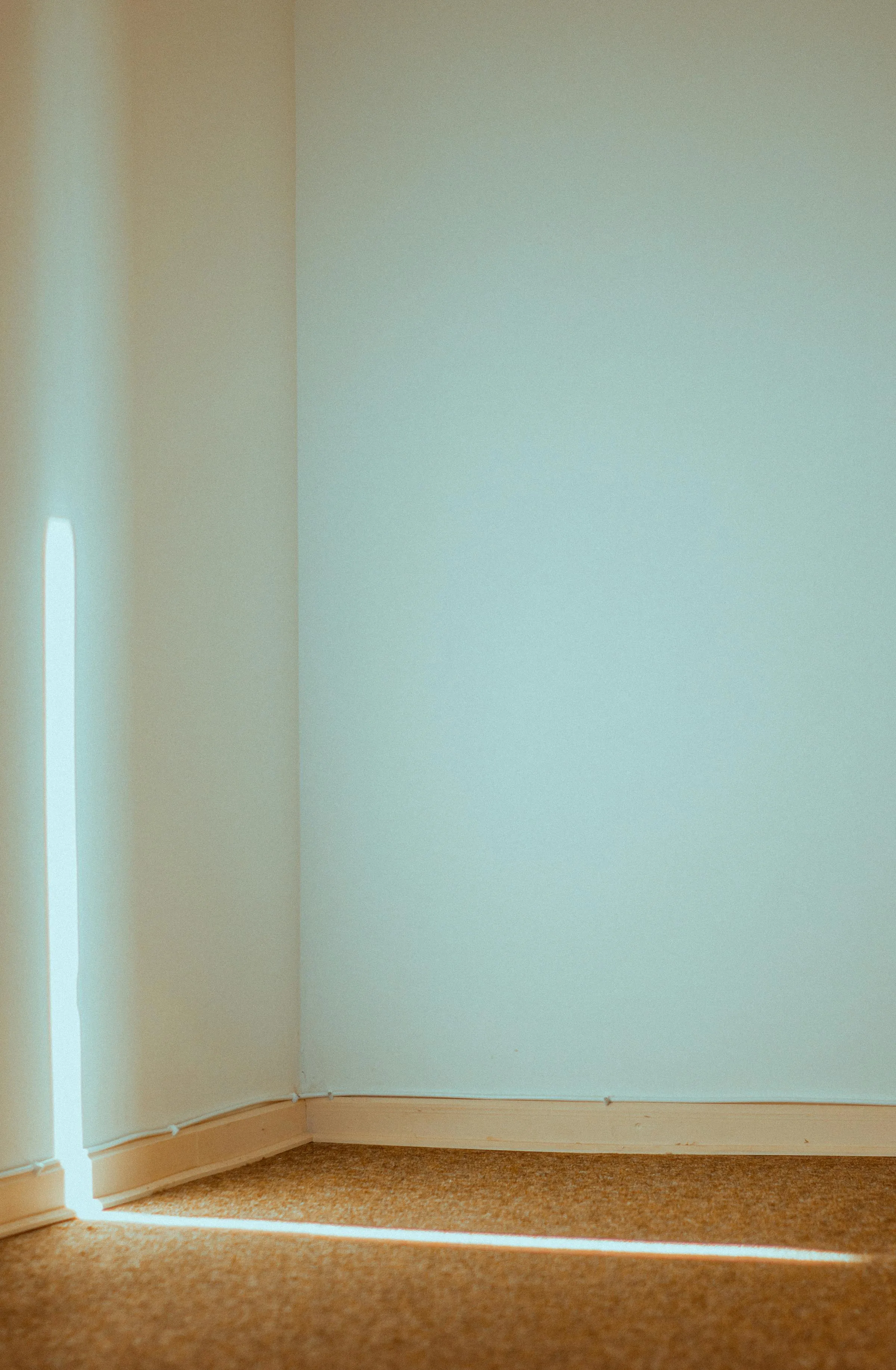 Haz de luz natural en esquina vacía de estuco blanco